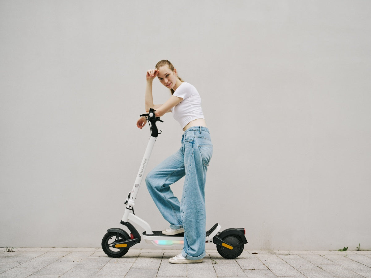 Rider leaning on an iSinwheel S Nova in White against a plain wall