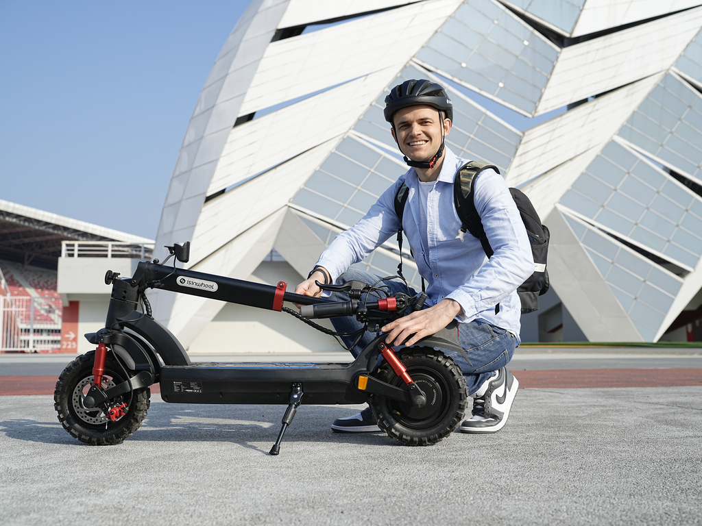 Rider crouched beside the iSinwheel GT2 on a paved plaza