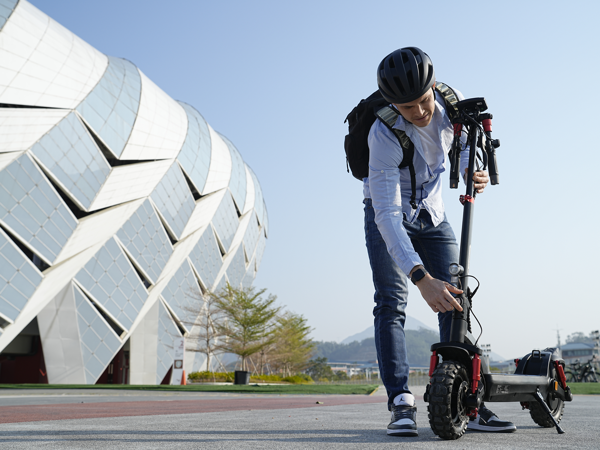 Rider lifting the iSinwheel GT2 by the stem after folding it