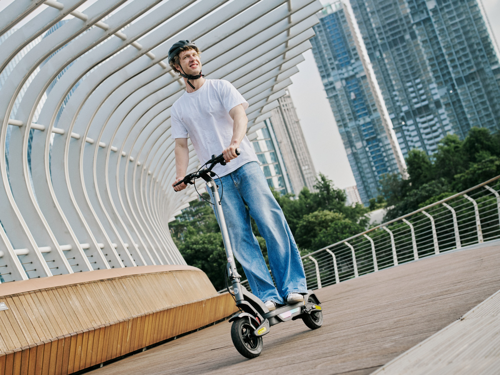 Rider on an iSinwheel S Nova crossing a curved city footbridge