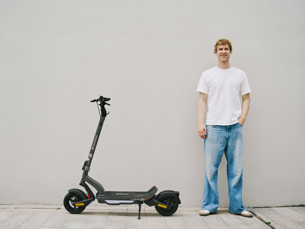 Man standing beside an iSinwheel S Nova in Gray against a plain wall
