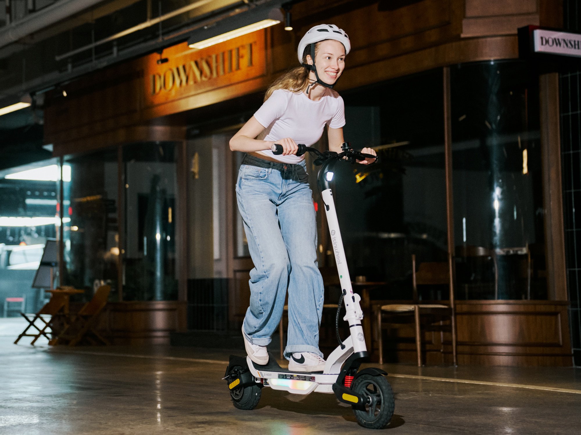 Rider on an iSinwheel S Nova in White outside a lit storefront at night