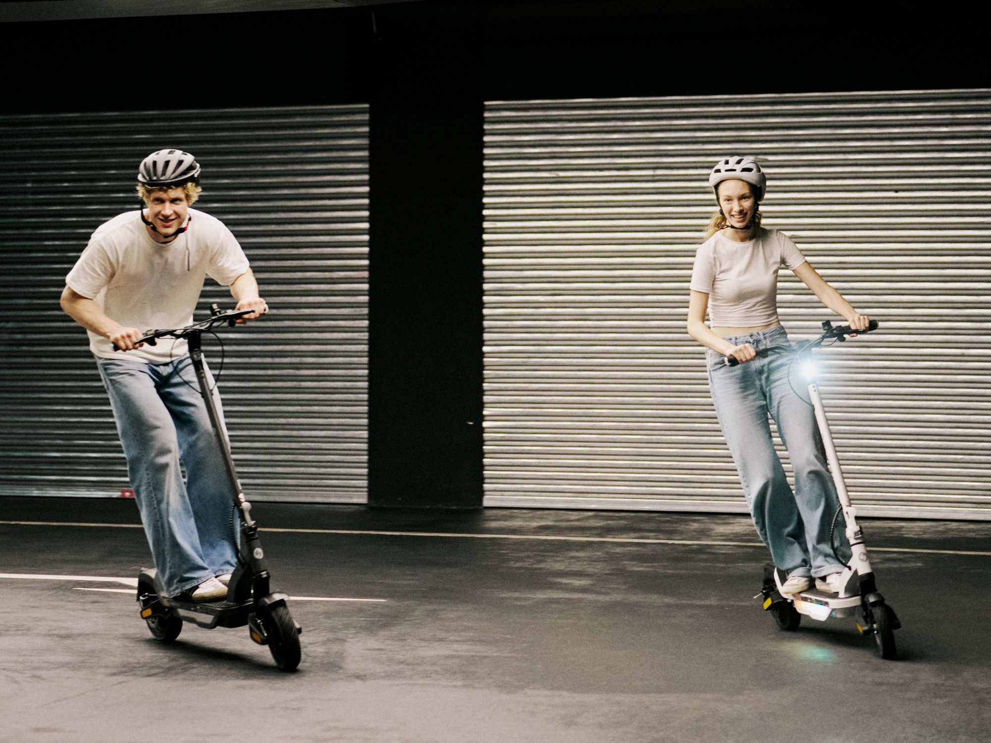 Two riders on iSinwheel S Nova scooters at night